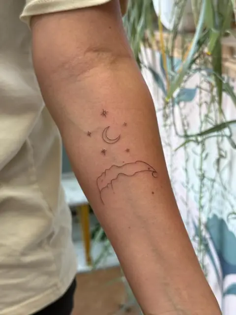 Moon, stars, and a mountain line — all in a single quiet stroke.
